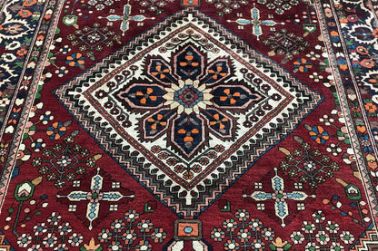 Rug: central diamond pattern with cross ornaments, dark red background