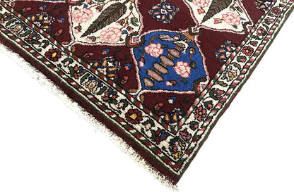 Persian Bakhtiari rug with border, burgundy background and blue motifs, fringes.
