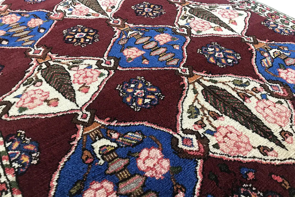 Close-up view of a Bakhtiari rug with colorful diamonds, floral ornaments, and a decorative border.