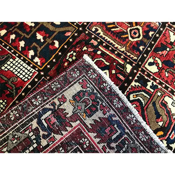 Close-up of a Bakhtiari oriental rug: various motifs, diamonds, and stepped patterns in dark red