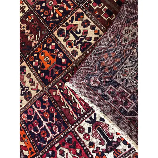 Carpet detail from the side; bold diamonds and ornaments in burgundy, blue, and beige