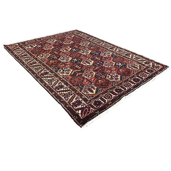 Rectangular Persian rug with a central field and borders, dark red and blue on beige