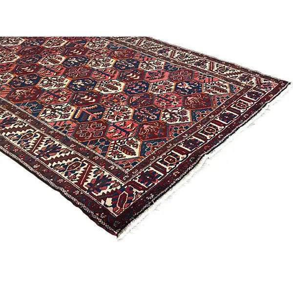 Persian rug with decorative border and colorful geometric pattern, dark red, blue, cream