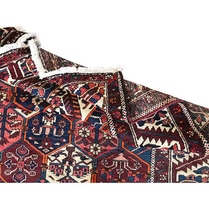 Persian rug corner with fringes and pattern, dark red, blue, cream