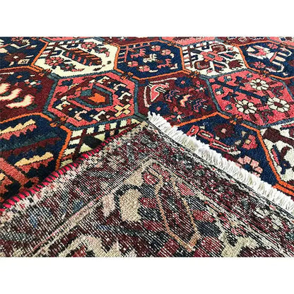 Persian carpet detail with fringed edge and ornaments, red, blue, beige