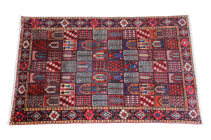 Oriental rug with a geometric pattern in red, blue, and beige, spread out in a rectangular shape