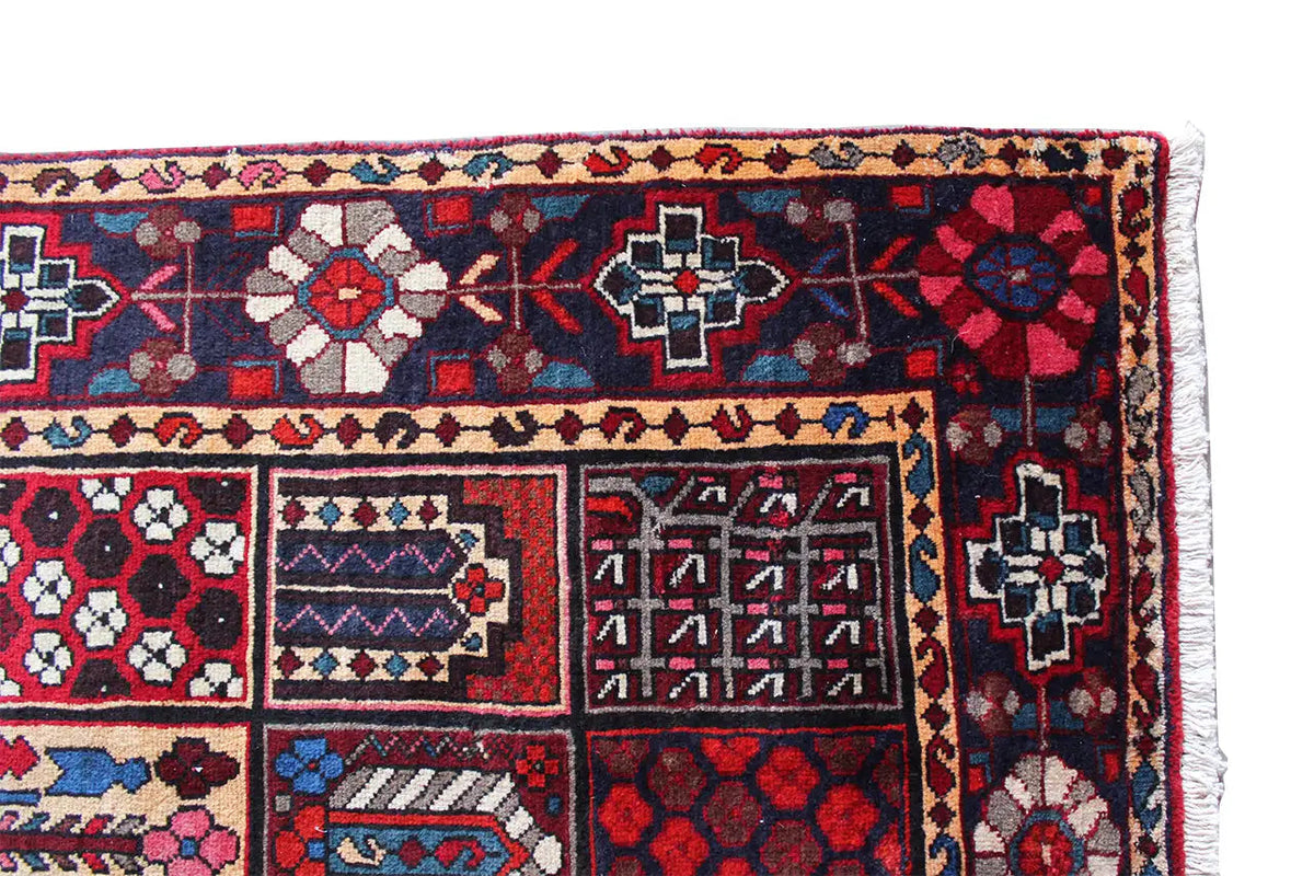 Rug corner with a floral and geometric pattern in dark red, blue, and cream