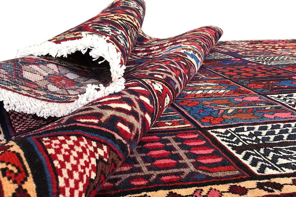 Close-up: rolled-up rug with a multicolored pattern, fringes, and a dense weave structure