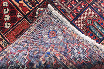 Close-up of the rug’s edge: a light woven pattern in blue, red, and cream with fringes