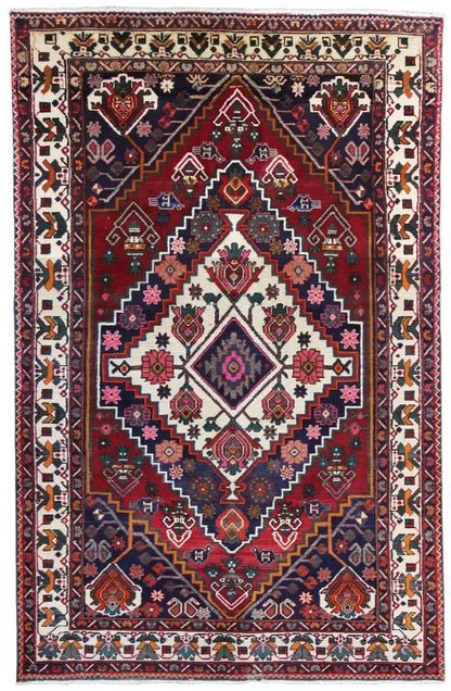 Oriental rug with a red central medallion, blue border, and floral and geometric patterns