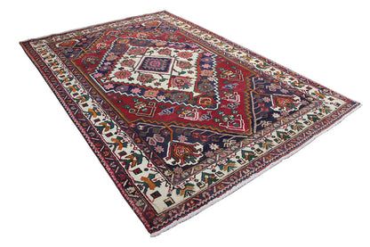 Oriental rug in diagonal view, red and dark blue, central tile frame, border