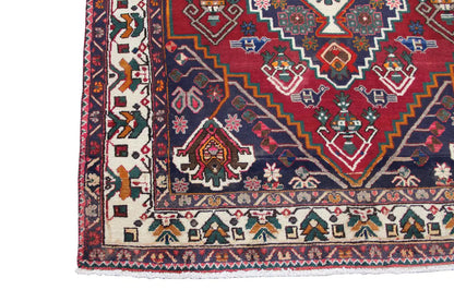 Close-up of a carpet edge with a border and geometric shapes, red, blue, cream-colored