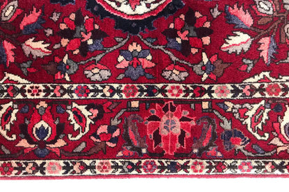 Close-up: red carpet pattern with floral ornaments, dark blue background, and decorative border.