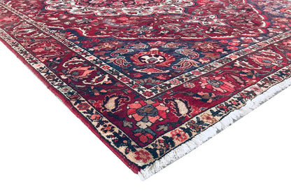 Carpet corner with hem: red pattern, dark blue area, and multicolored decorative border.