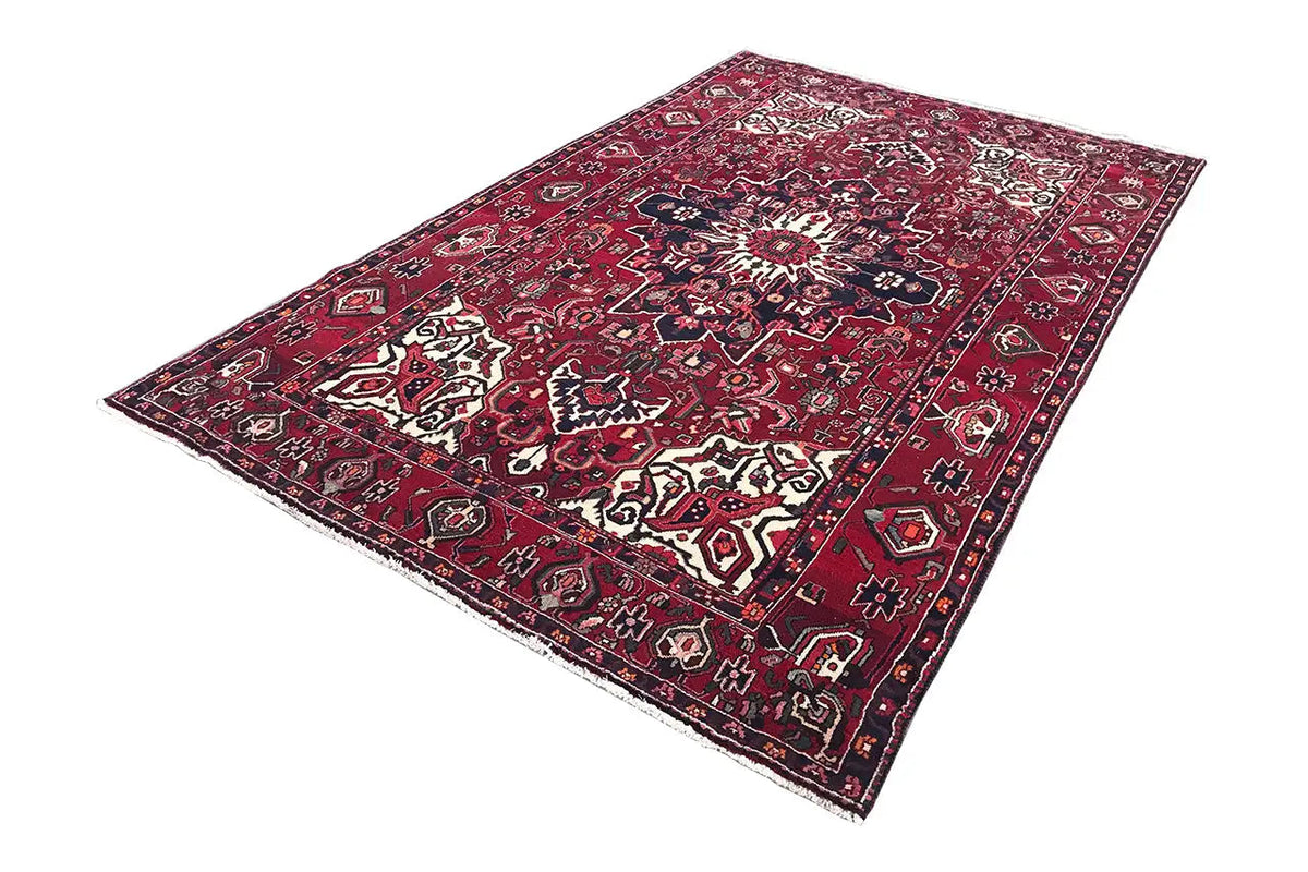 Rectangular rug with a red background, dark blue, and white ornaments