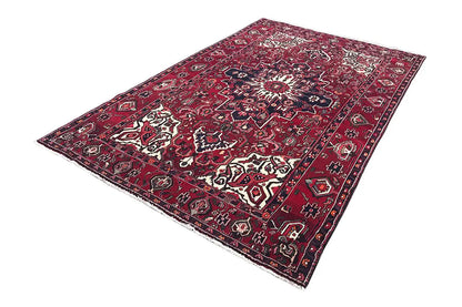 Rectangular rug with a red background, dark blue, and white ornaments