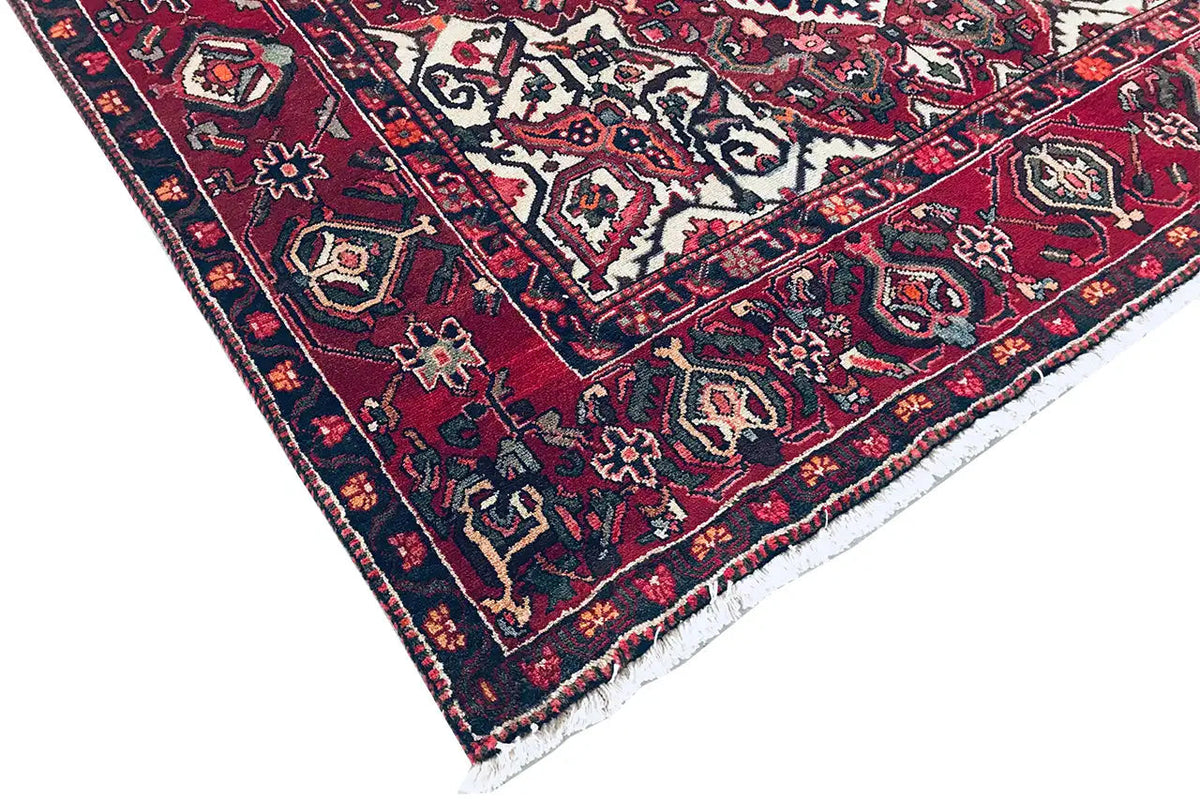 Rug corner with a dense pattern in red, blue, and white; textured pile weave