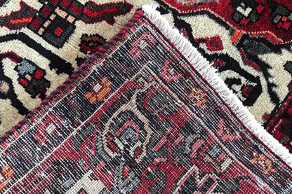 Carpet detail with a woven texture and diagonal patterns in red and dark blue