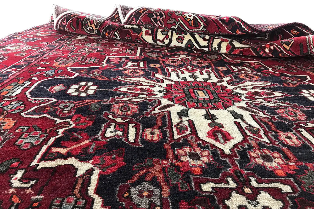 Rug laid out with a border pattern; red, dark blue and off-white with fringes