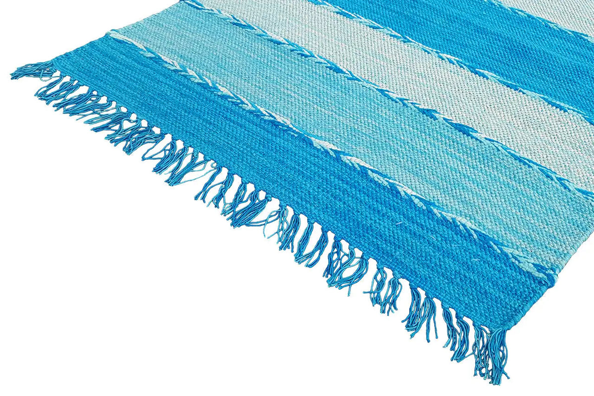 Kilim dhurrie rug detail: blue-and-white striped with a frayed edge