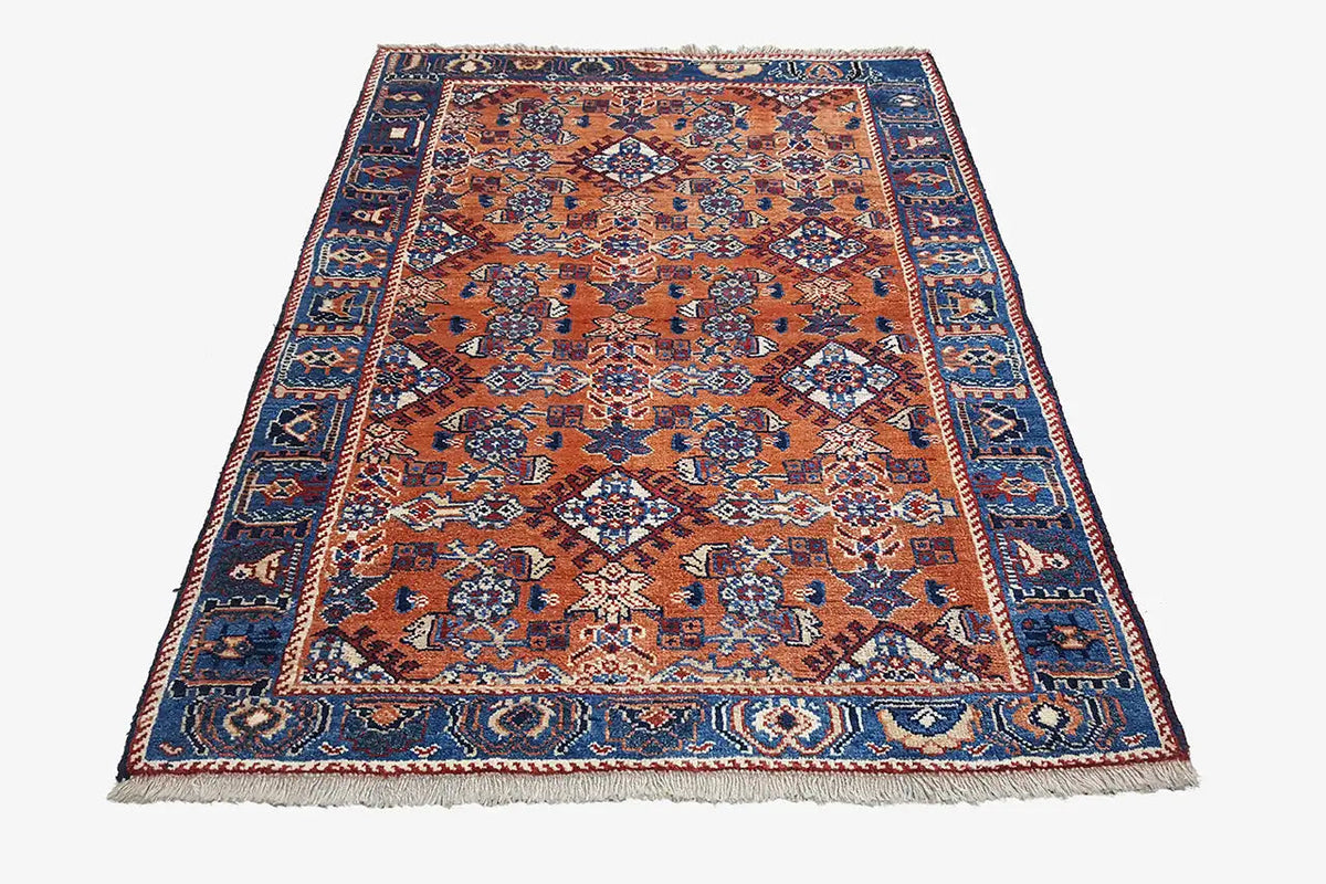Orange and blue rug with a fine geometric central pattern and borders