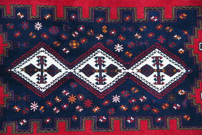 Multicolored rug with a geometric pattern in blue, red, and white