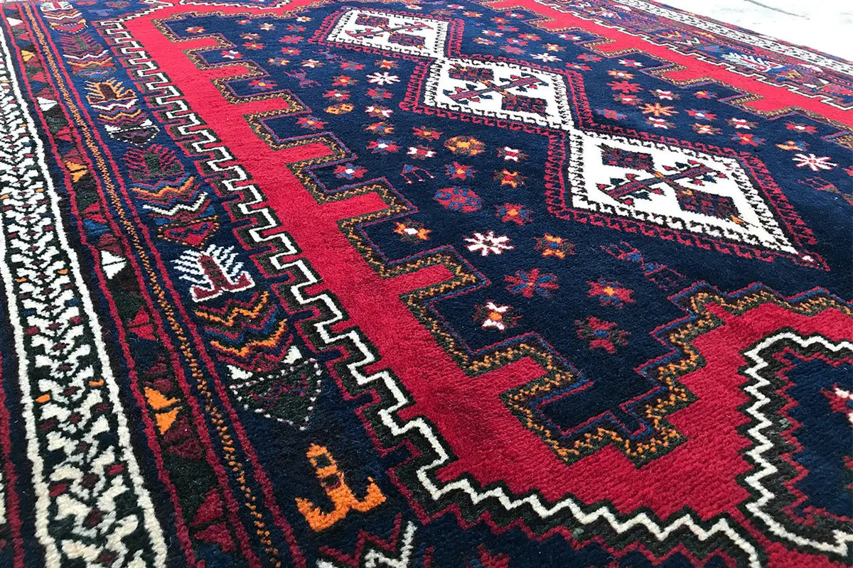 Carpet detail with a red central stripe and a blue-and-white zigzag border