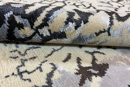 Designer rug with an abstract blue-black pattern, beige pile, and texture
