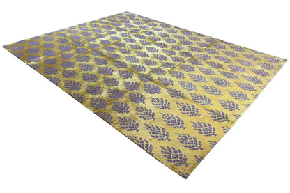 Designer rug with a yellowish-purple pattern, stretched out in a diagonal view