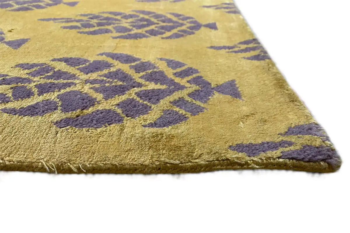 Designer rug corner with a purple pattern on a yellowish background and a fringed edge