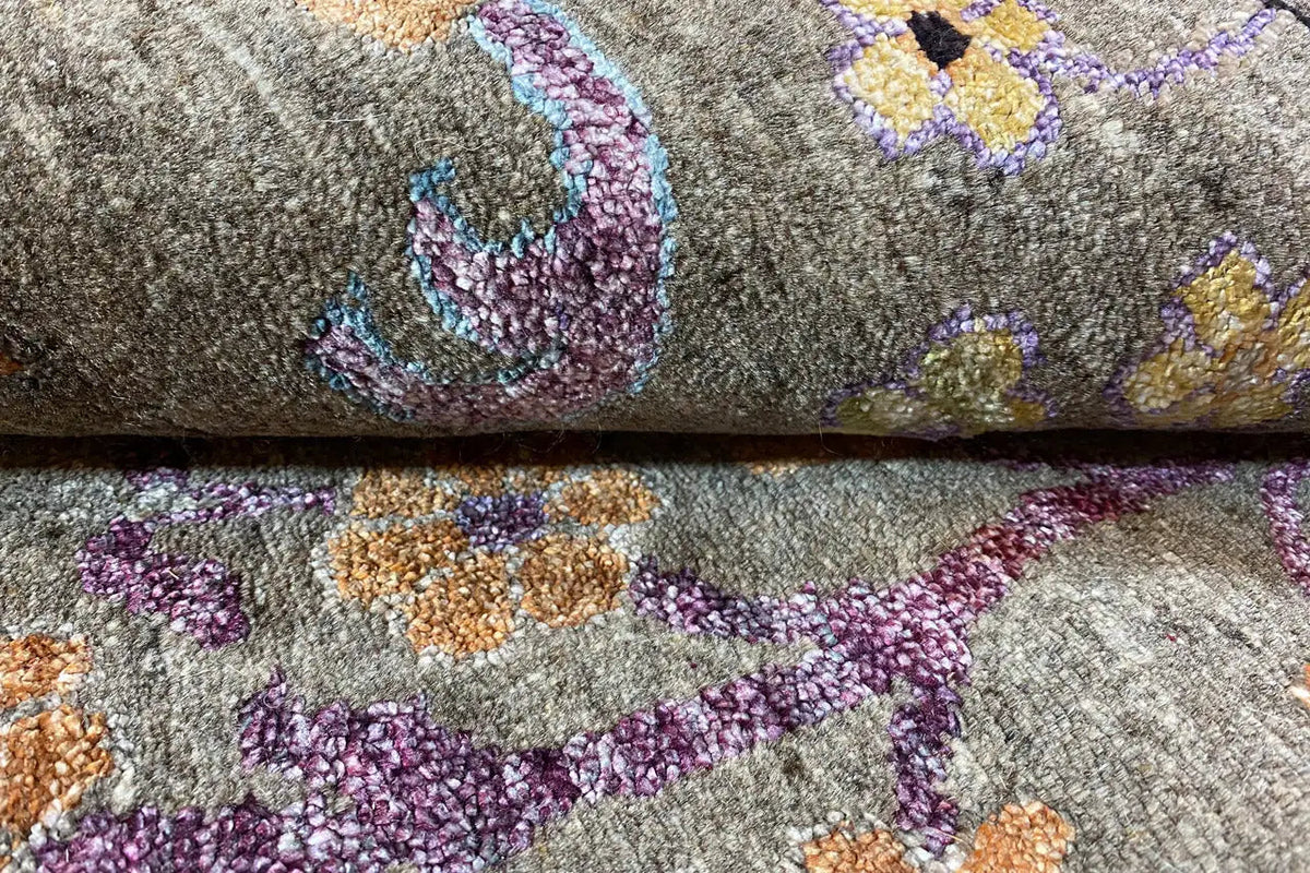 Close-up: gray carpet with blue, purple, and orange floral motifs, dense pile