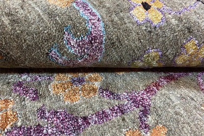 Close-up: gray carpet with blue, purple, and orange floral motifs, dense pile