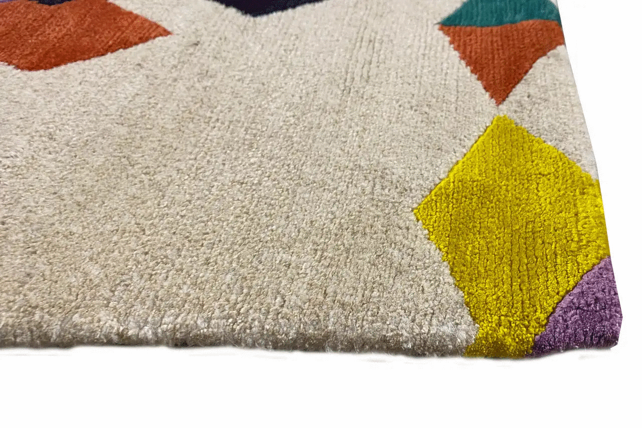 Rug corner with a light beige pile and colorful tile patterns (yellow, purple, orange).