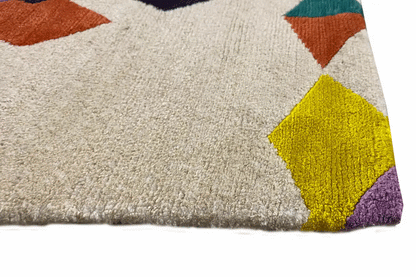 Rug corner with a light beige pile and colorful tile patterns (yellow, purple, orange).