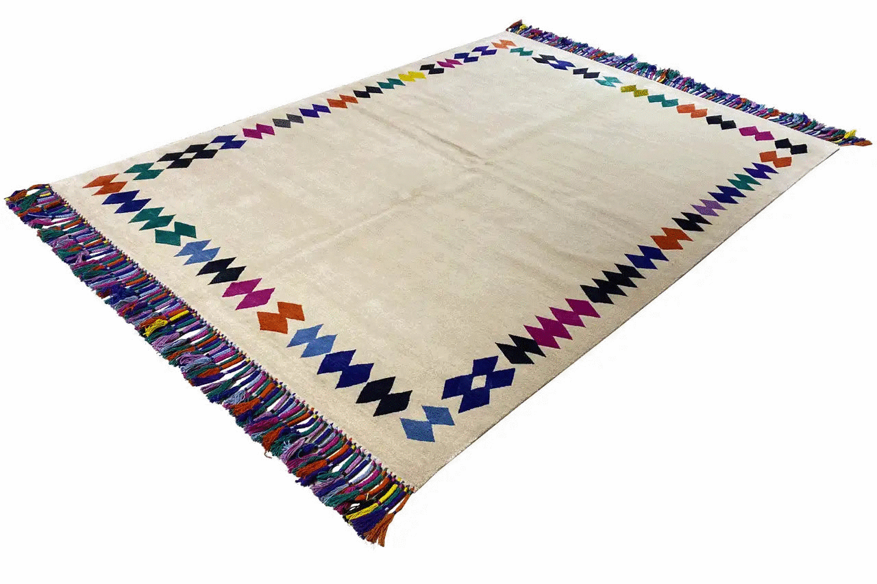 Rug with fringes, beige base, and colorful zigzag border decoration
