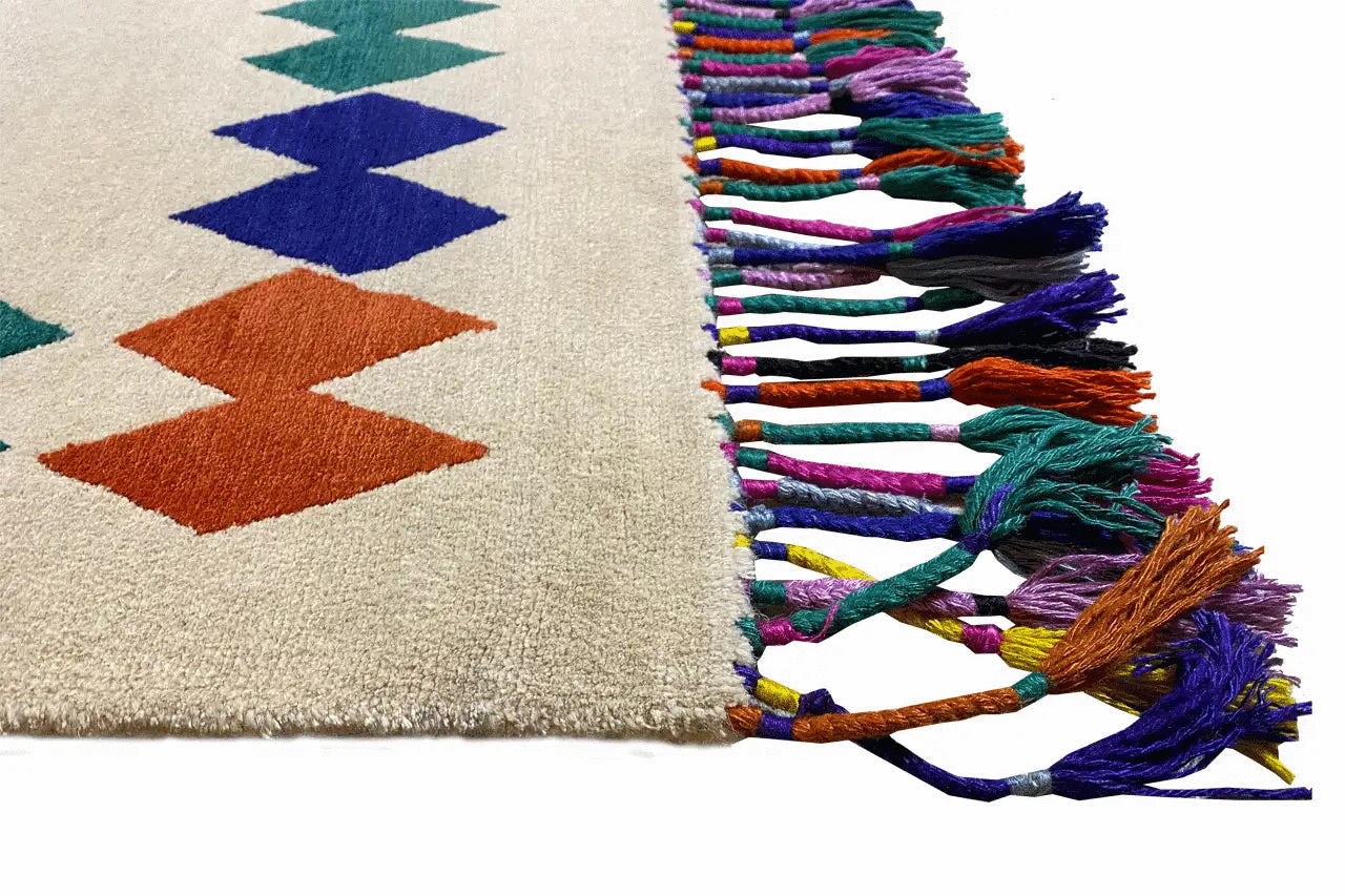Rug corner with colorful fringe and two-tone zigzag patterns
