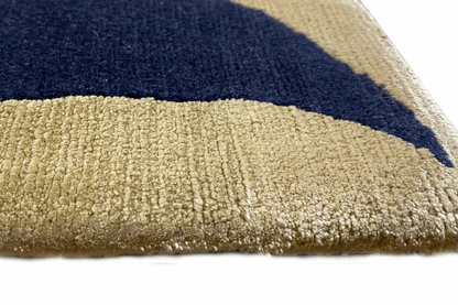 Carpet surface with a dark striped border and dense beige pile (close-up)
