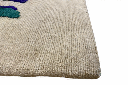 Corner view of carpet 172x242 cm with beige pile and neatly stitched edge