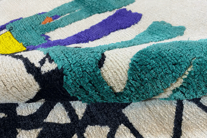 Detail rug 172x242 cm: turquoise appliqué and purple design details in the pattern