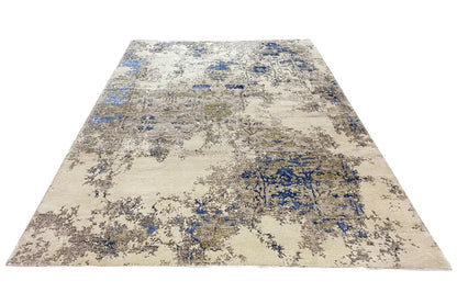 Rectangular rug with a beige background and a blue abstract block pattern