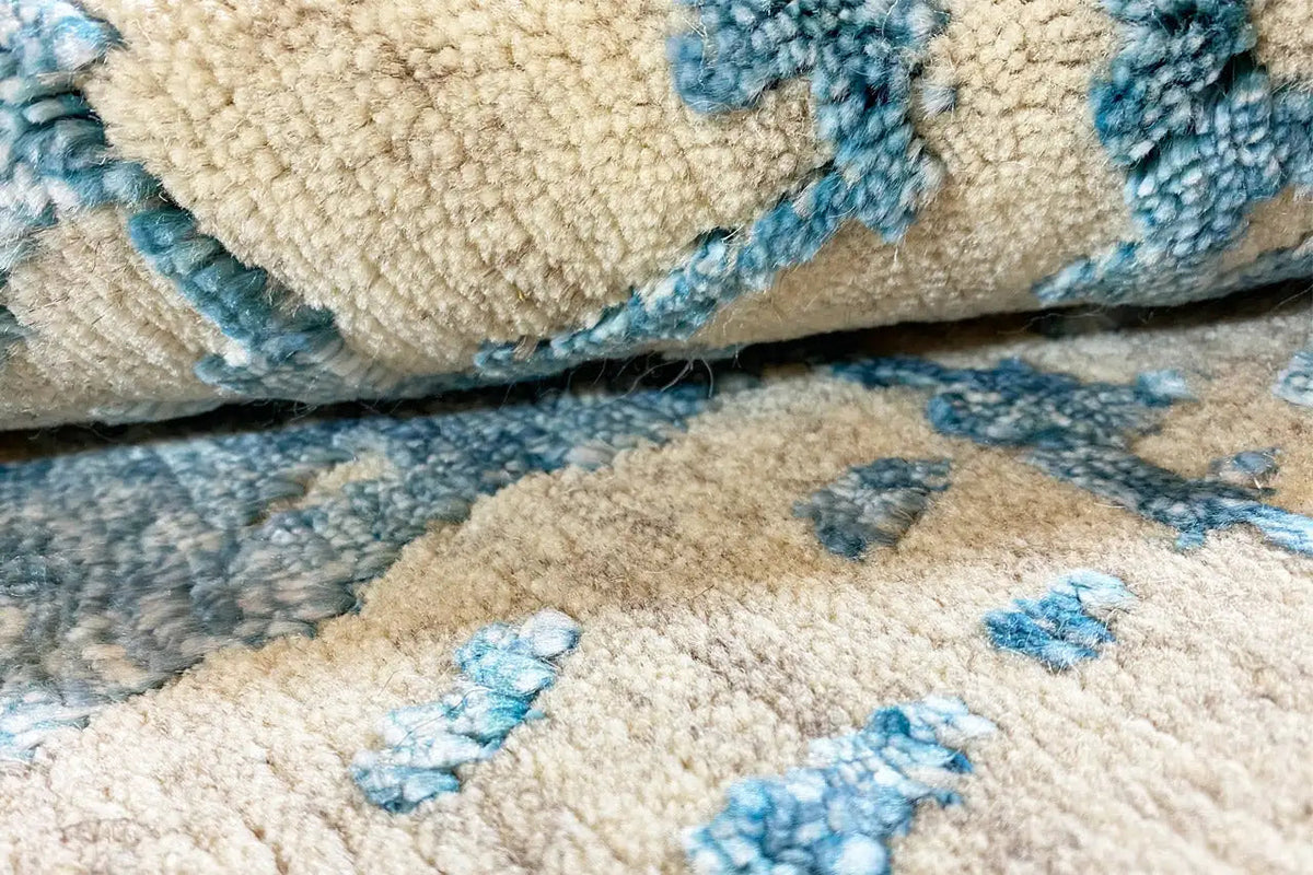 Carpet with beige pile and blue pattern, detail of the woven surface
