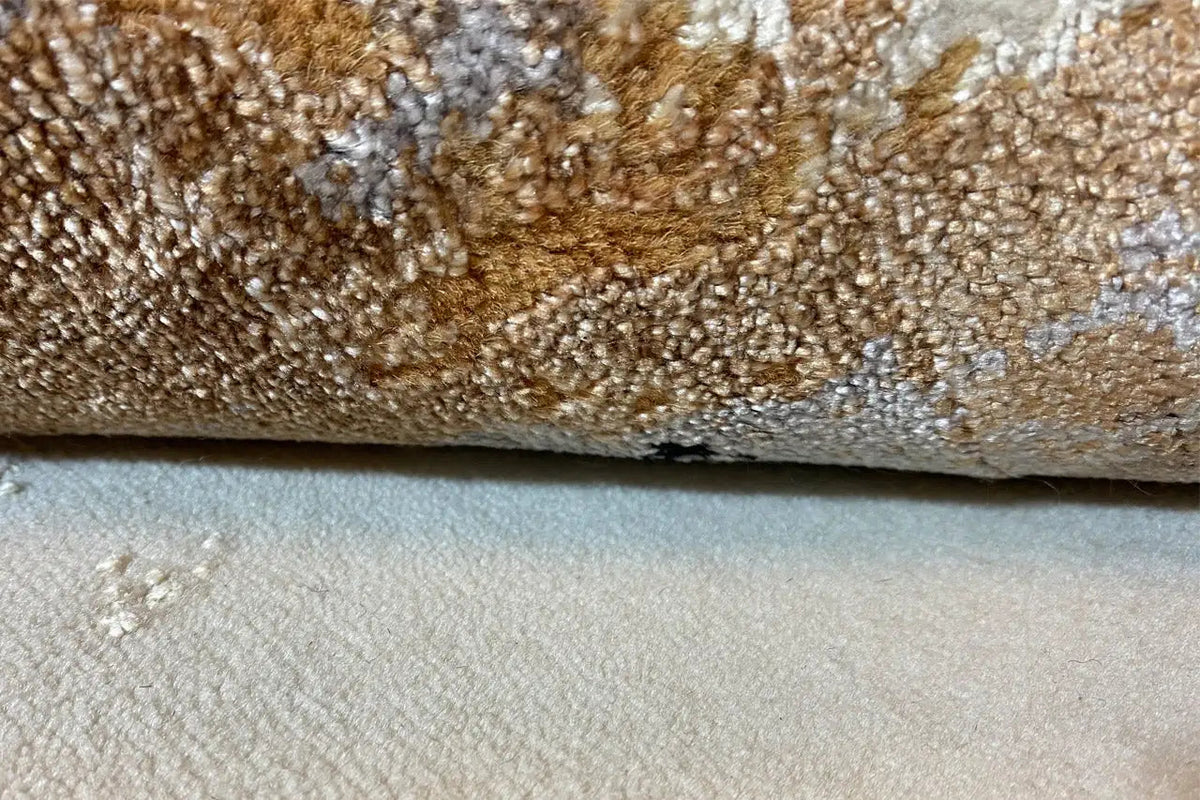 Carpet detail with pile in beige tones and brown-orange flecks