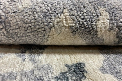 Designer rug close-up: short, soft pile texture in gray-beige with blue flecks