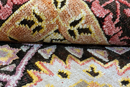 Carpet detail with a dense pile pattern in brown, pink, and dark gold
