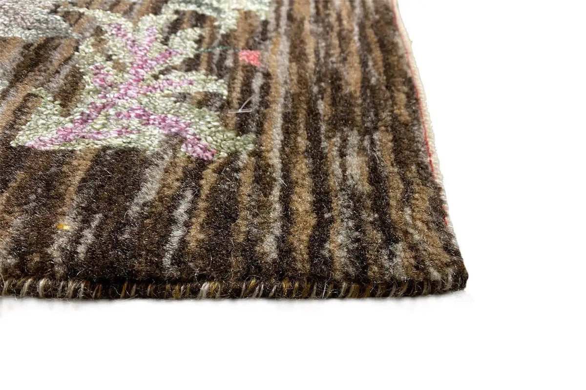 Rug corner with dark pile and a frayed fringe border