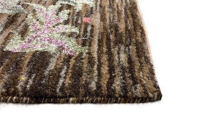 Rug corner with dark pile and a frayed fringe border
