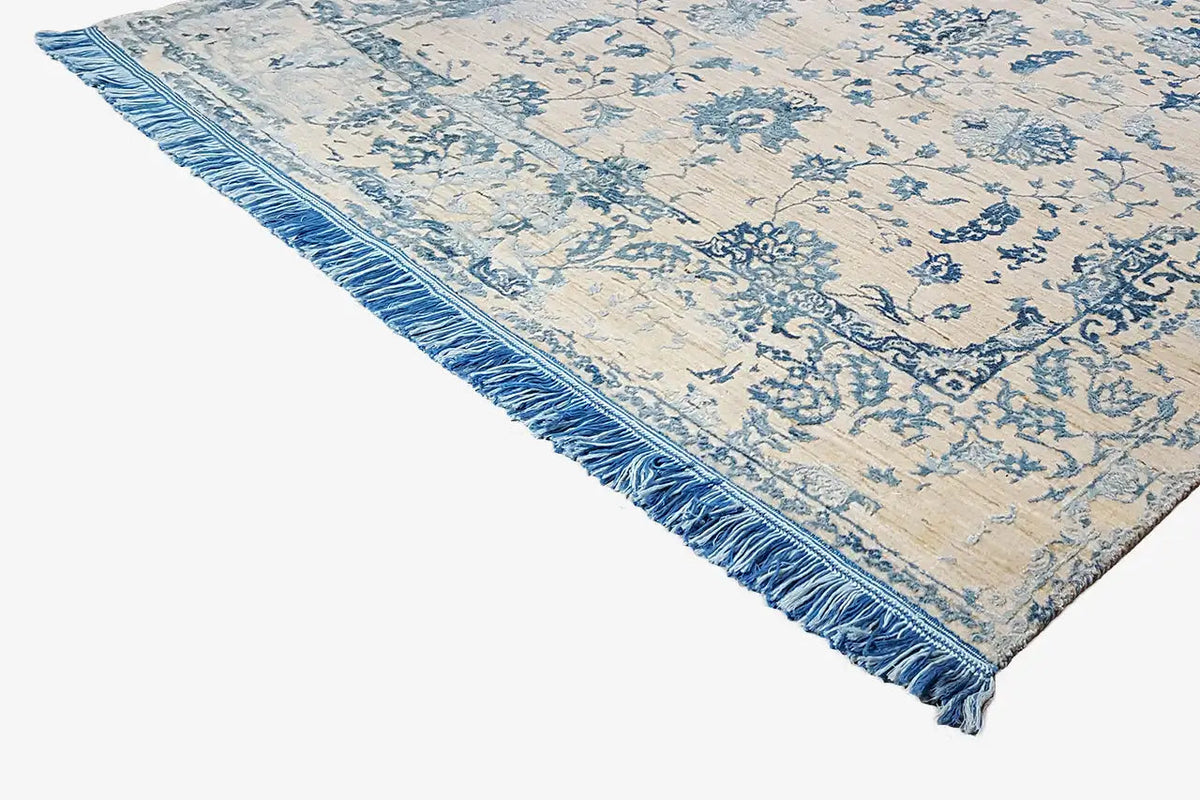Designer rug, corner with a blue floral pattern and fringed border