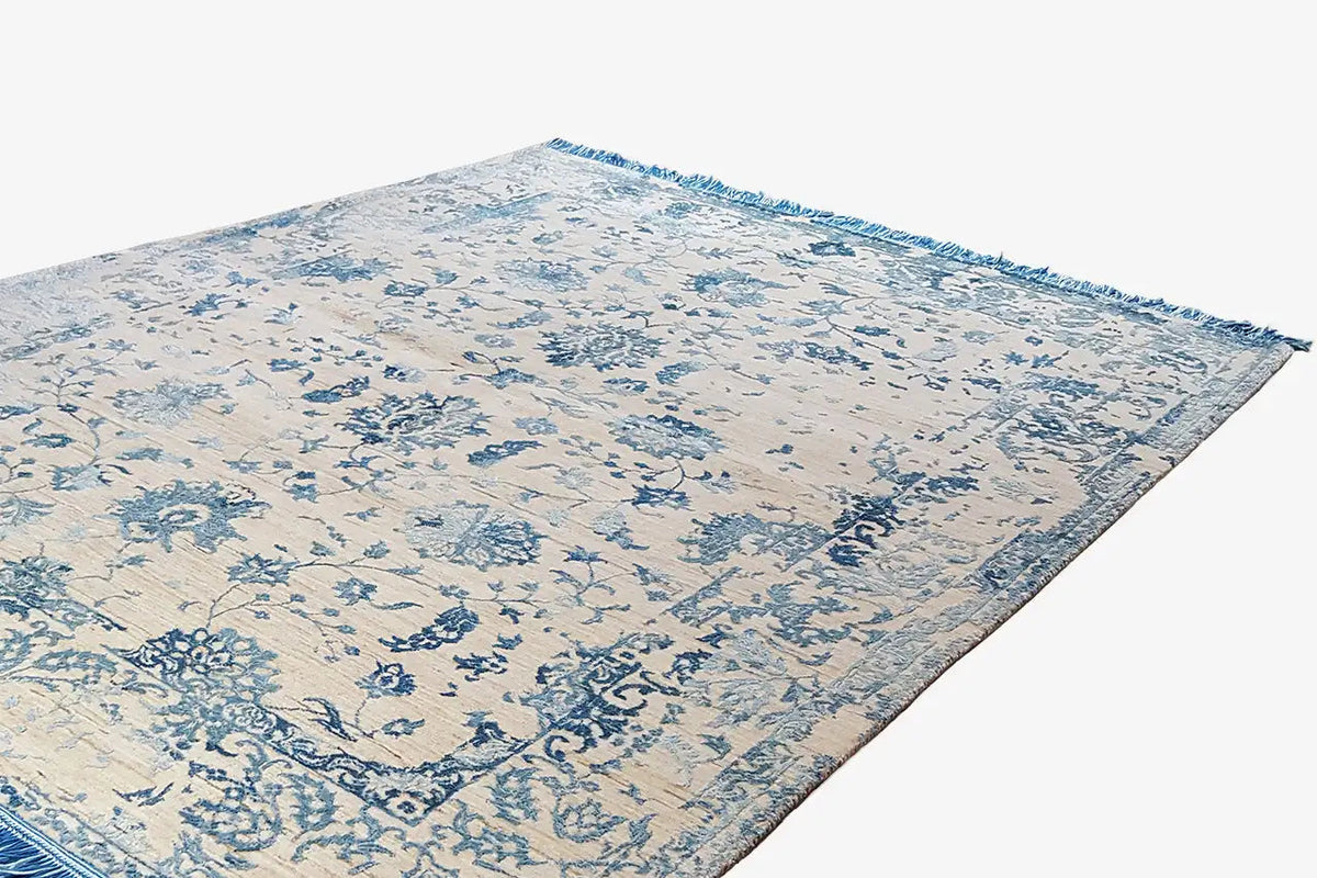 Designer rug with a light beige background and blue ornamental pattern, fringes