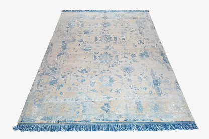 Rectangular designer rug with blue ornamental pattern and fringed edges