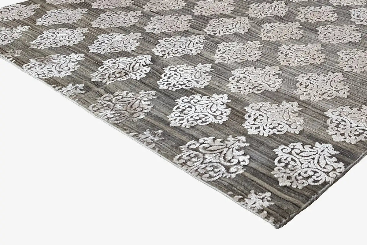 Designer rug with gray pile and white ornamental pattern, side perspective